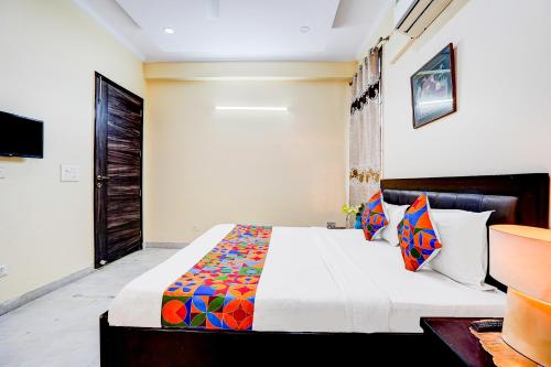 a bedroom with a large bed with colorful pillows at FabHotel Sarala Residency in Noida