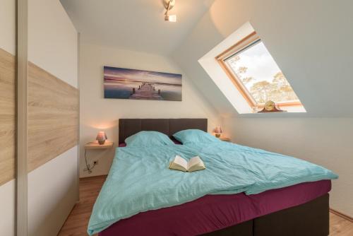 a bedroom with a bed with a book on it at Fewo Lebensart - in bester Lage, mit TG und Balkon in Baabe