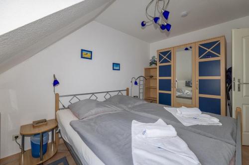a bedroom with a bed with towels on it at Fewo Meeresleuchten - Strandkorb auf Balkon, TG in Baabe