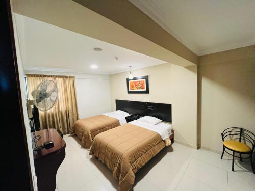 a hotel room with two beds and a fan at Royal Garden Hotel in Lima