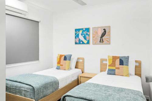 two beds in a room with white walls at Hidden Gem - 3BR Home - Cairns in Edge Hill
