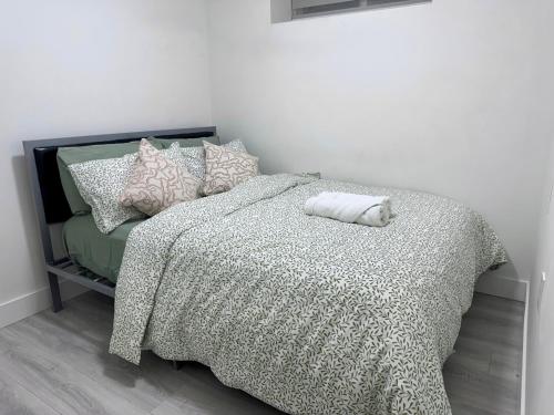 a bedroom with a bed with a comforter and pillows at Comfort 2 BR Vancouver! in Vancouver