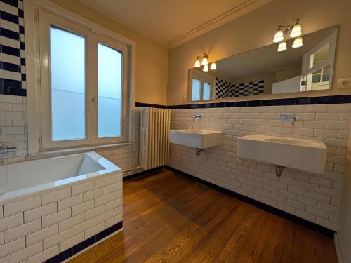 a bathroom with two sinks and a large window at Scenic villa in Borgloon with garden in Borgloon