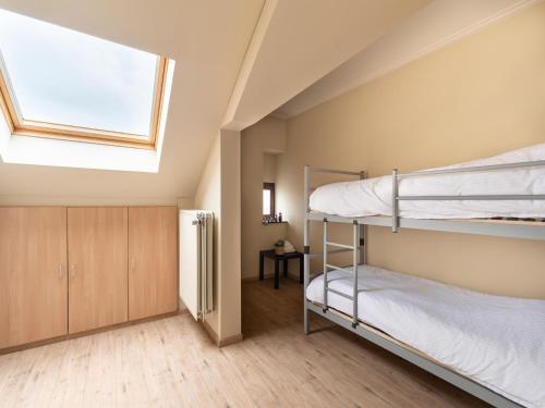 a bedroom with two bunk beds and a skylight at Scenic villa in Borgloon with garden in Borgloon