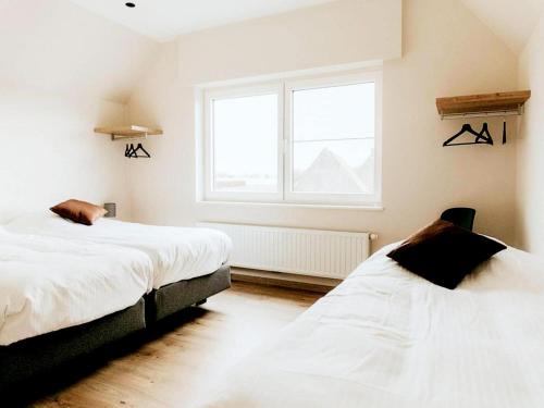 two beds in a room with a window at Luxury Holiday Home in Wingene for 12 in Wingene