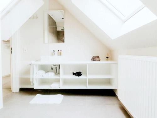 a white bathroom with a sink and a mirror at Luxury Holiday Home in Wingene for 12 in Wingene