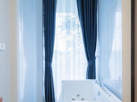 a bathroom with a tub and a large window at Villanin Hotel & Spa Golden Triangle in Ban Wiang Nuea