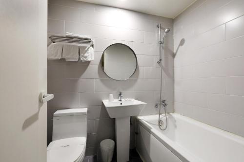a bathroom with a toilet and a sink and a tub at Hotel Yam Bucheon Station in Bucheon