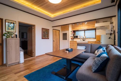 a living room with a couch and a table at Immaculate Private Family Cottage with Hot Spring in Towada