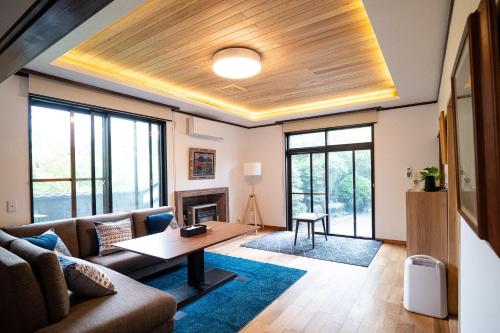 a living room with a couch and a table at Immaculate Private Family Cottage with Hot Spring in Towada