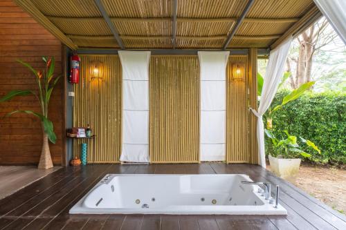 a bath tub sitting in the middle of a room at The Tree Riverside Resort Kaeng Krachan in Kaeng Krachan