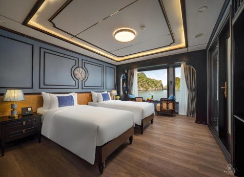 two beds in a room with a large window at AIME'E CRUISES - Halong Bay in Ha Long