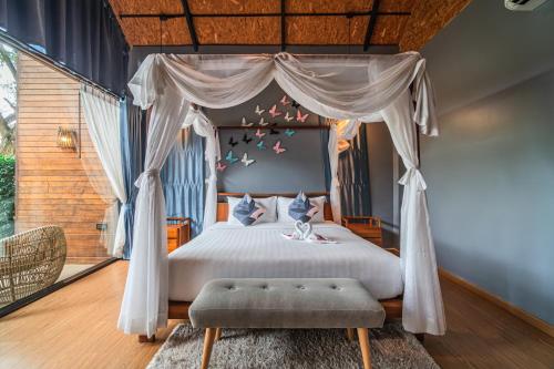 a bedroom with a bed with a canopy at The Tree Riverside Resort Kaeng Krachan in Kaeng Krachan