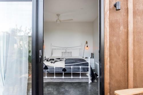 a bedroom with a bed through a glass door at Walnut Studio in Raglan