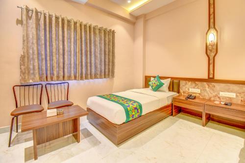 a bedroom with a bed and a desk and a chair at FabHotel Ayodhya in Pune