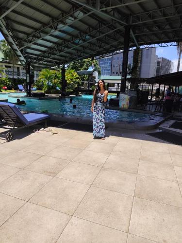 a woman standing in front of a swimming pool at Ronika devi in Savu