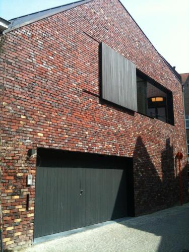 ceglany budynek z bramą garażową i oknem w obiekcie B-Square w Brugii