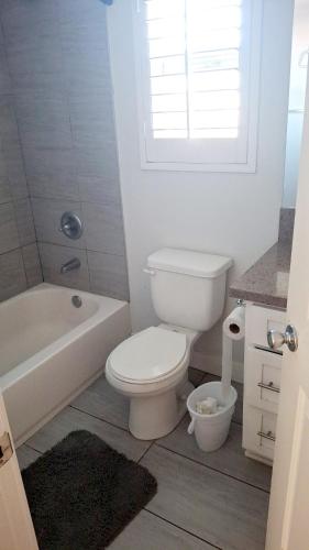 a bathroom with a toilet and a tub and a sink at Normandie Vibes Hostel in Los Angeles