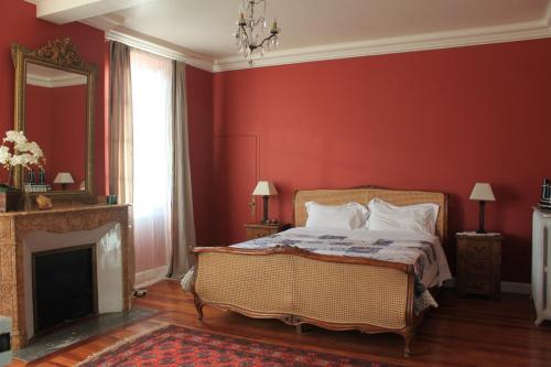 a bedroom with a bed with red walls and a fireplace at B&B Coup de Coeur in Bram