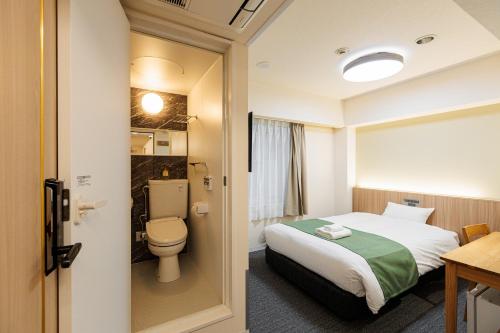 a hotel room with a bed and a toilet at アメ村ガーデンホテルAmemura Garden Hotel in Osaka
