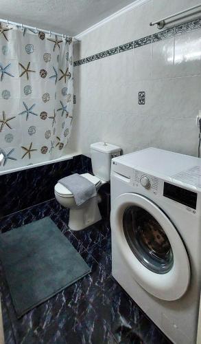 a bathroom with a washing machine and a toilet at Faros AXD Apartment in Alexandroupoli