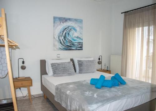 a bedroom with a bed with blue shoes on it at Faros AXD Apartment in Alexandroupoli