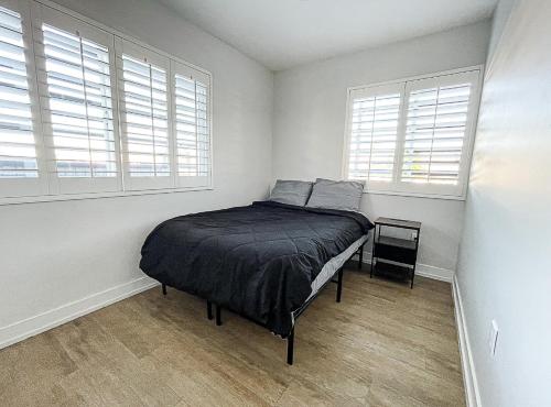 a bedroom with a bed in a room with windows at Normandie Vibes Hostel in Los Angeles