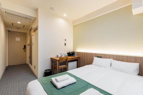 a hotel room with a bed and a desk at アメ村ガーデンホテルAmemura Garden Hotel in Osaka