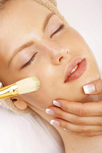 a woman brushes her face with a brush at Hotel Columbia Terme in Abano Terme