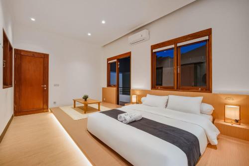 a large white bed in a room with windows at Kuma Villa Bandung in Bandung