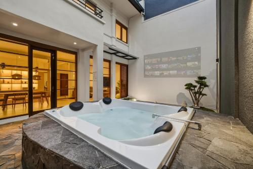 a jacuzzi tub in the middle of a room at Kuma Villa Bandung in Bandung