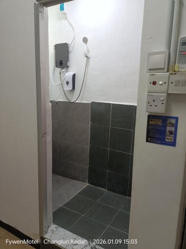 a bathroom with a shower with a phone on the wall at Fywen Motels in Changlun