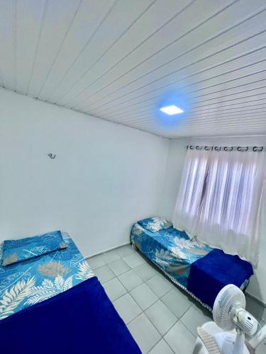 a small room with two beds and a window at Casa Barreirinhas in Barreirinhas