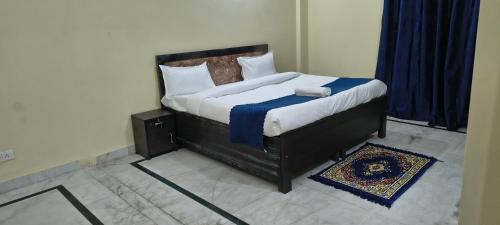a bedroom with a large bed with a blue blanket at Pb Legacy hotel in Noida