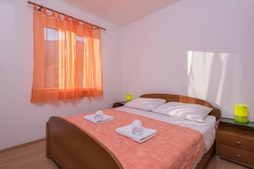 a bedroom with a bed with two towels on it at Apartments Maestral in Orebić