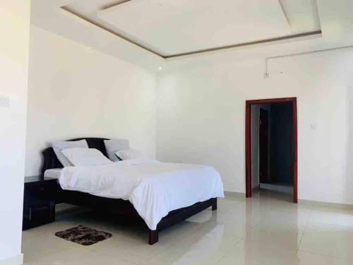 a bedroom with a bed in a white room at Villa with 4 bedrooms in Lusaka