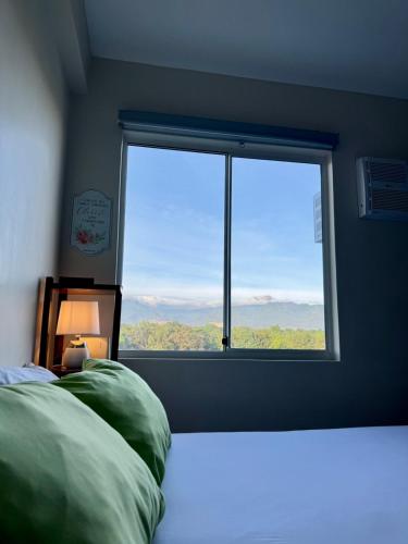 a bedroom with a large window with a view at Unit 28 Mountain View Studio by Ems in Dumaguete