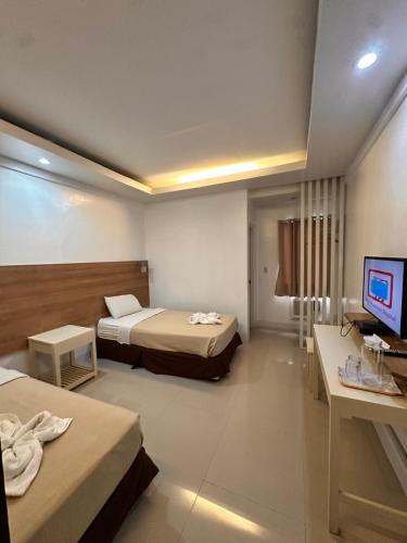 a hotel room with two beds and a television at Pietros Square in Butuan