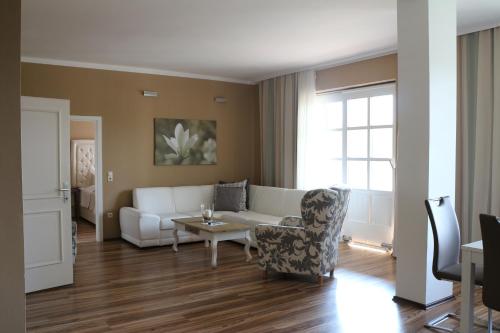 a living room with a white couch and a table at Residenz am See in Sankt Kanzian