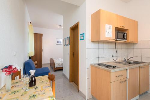 a kitchen and dining room with a table and a microwave at Apartments Maestral in Orebić