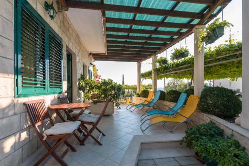 a patio with chairs and a table and awning at Apartments Maestral in Orebić