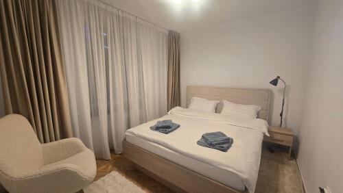 a bedroom with a bed with two towels on it at Shakespeare Central Apartment in Craiova