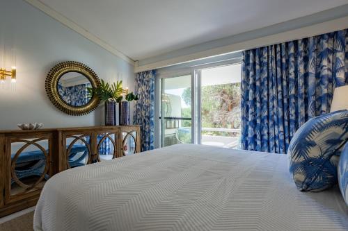 a bedroom with a large bed and a window at The Palm Nest in Quinta do Lago