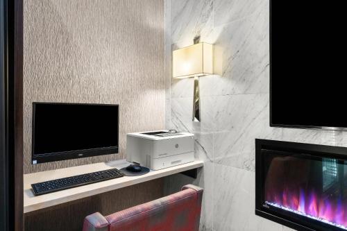 a room with a computer and a desk with a monitor and a keyboard at Comfort Inn Prospect Park-Brooklyn in Brooklyn