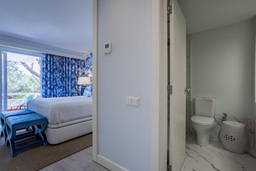 a bedroom with a bed and a toilet at The Palm Nest in Quinta do Lago