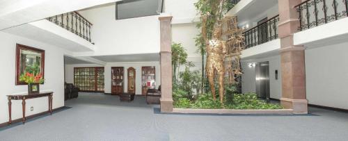 an empty lobby with a plant in the middle at Radisson Hotel & Convention Center Toluca in Toluca