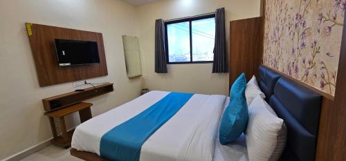 a hotel room with a bed and a window at Hotel Empire in Vapi