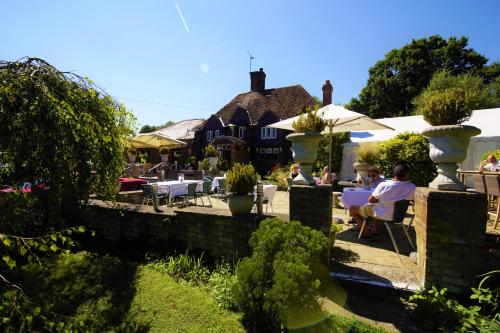 a group of people sitting at tables in a garden at Who'd A Thought It in Lenham
