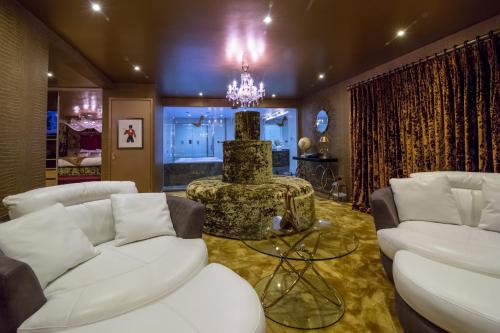 a living room with white furniture and a chandelier at Who'd A Thought It in Lenham