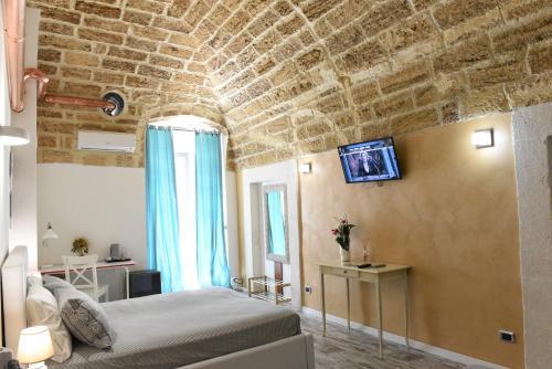 a bedroom with a bed and a brick wall at B&B Il Grifone in Gioia del Colle